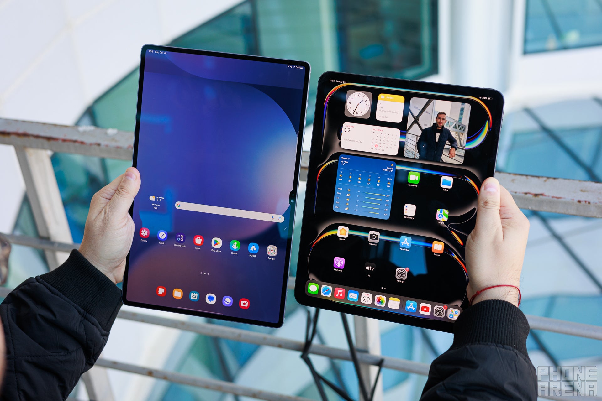 Galaxy Tab S10 Ultra and iPad Pro M4 13&quot; held in two hands, the screens are showing the homescreens